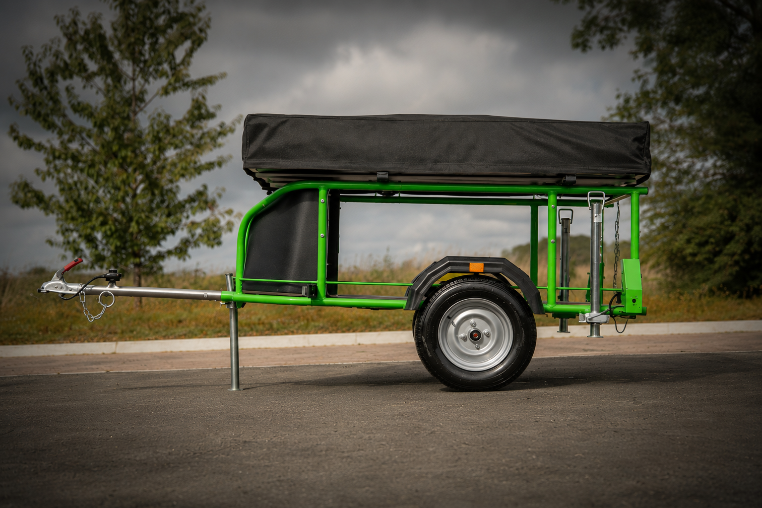 Side profile of a Nomad Micro trailer with green steel chassis, TentBox and towing hardware
